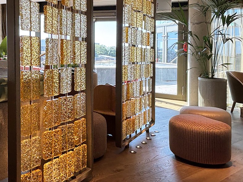 Cast glass screen at The BoTree hotel, London, with the rooftop terrace seen through the glazed doors beyond